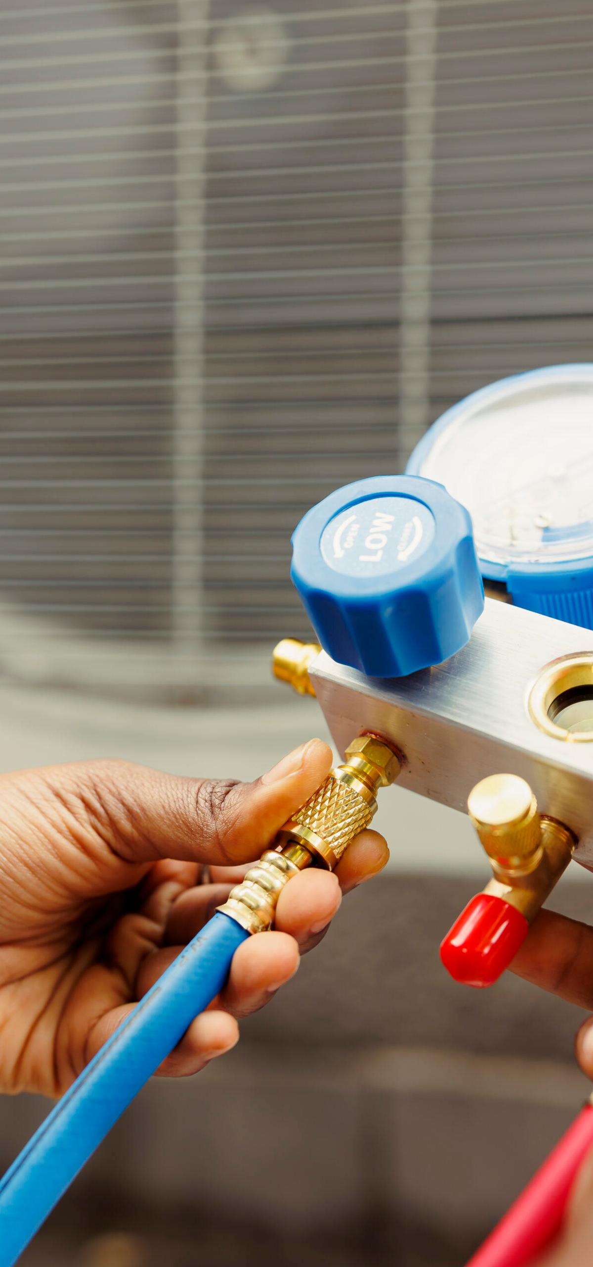 Climate Pro technician checking refrigerant levels on an AC unit